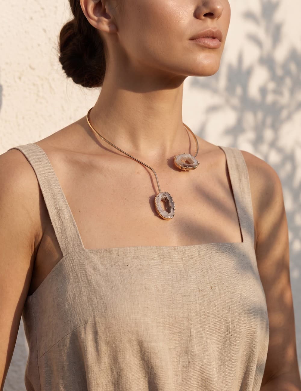 Choker de ágata natural em fatias, com banho dourado, sobre vestido de linho cru na luz de fim de tarde